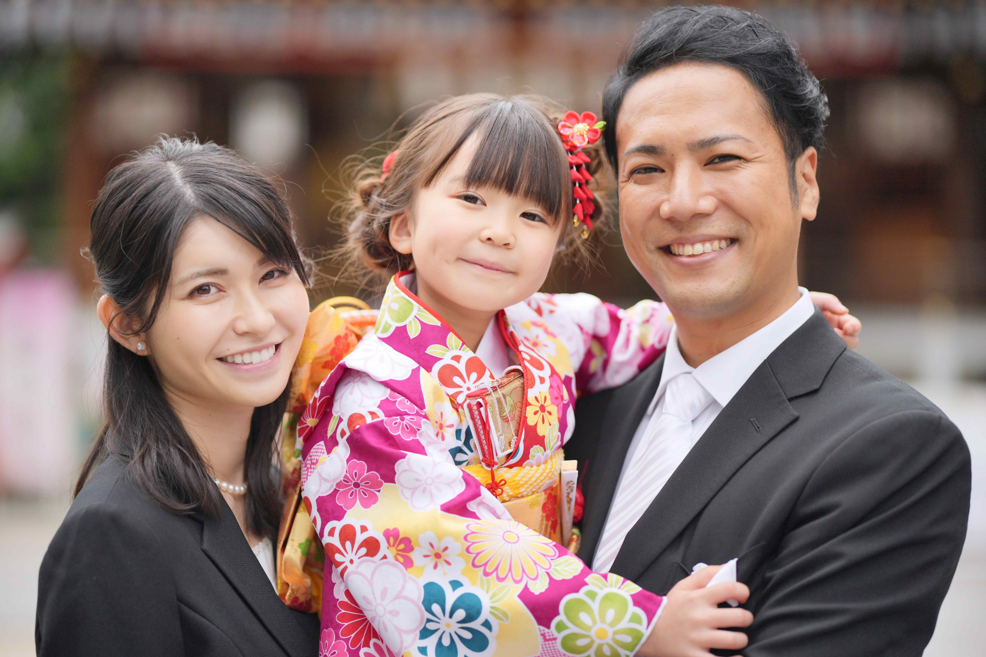 七五三の晴れ着姿で笑顔を見せるお子さまとご両親