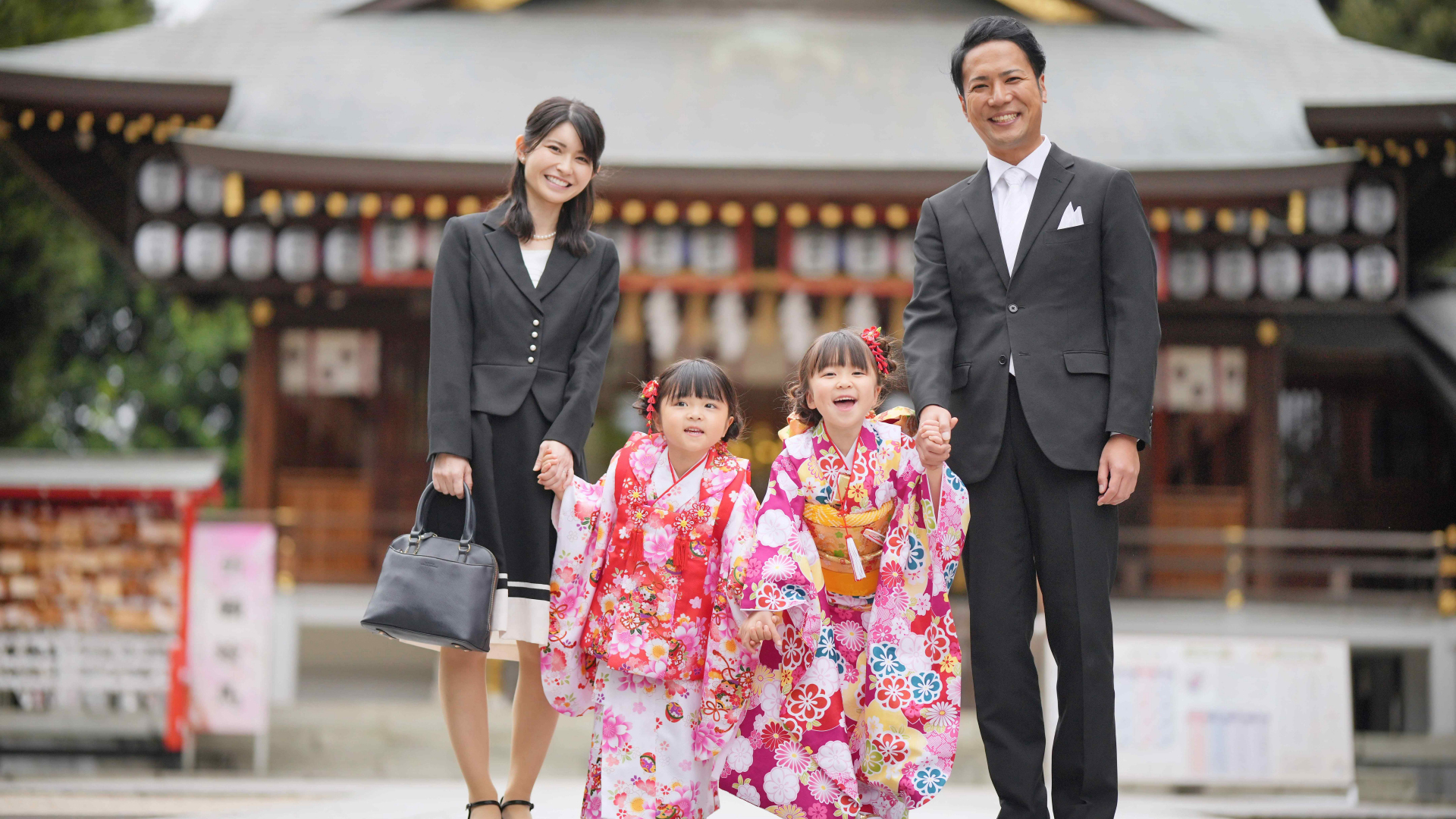 神社の前で七五三の記念撮影をするご家族